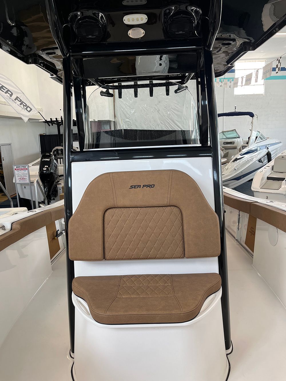 The front of a boat with a seat and a windshield.