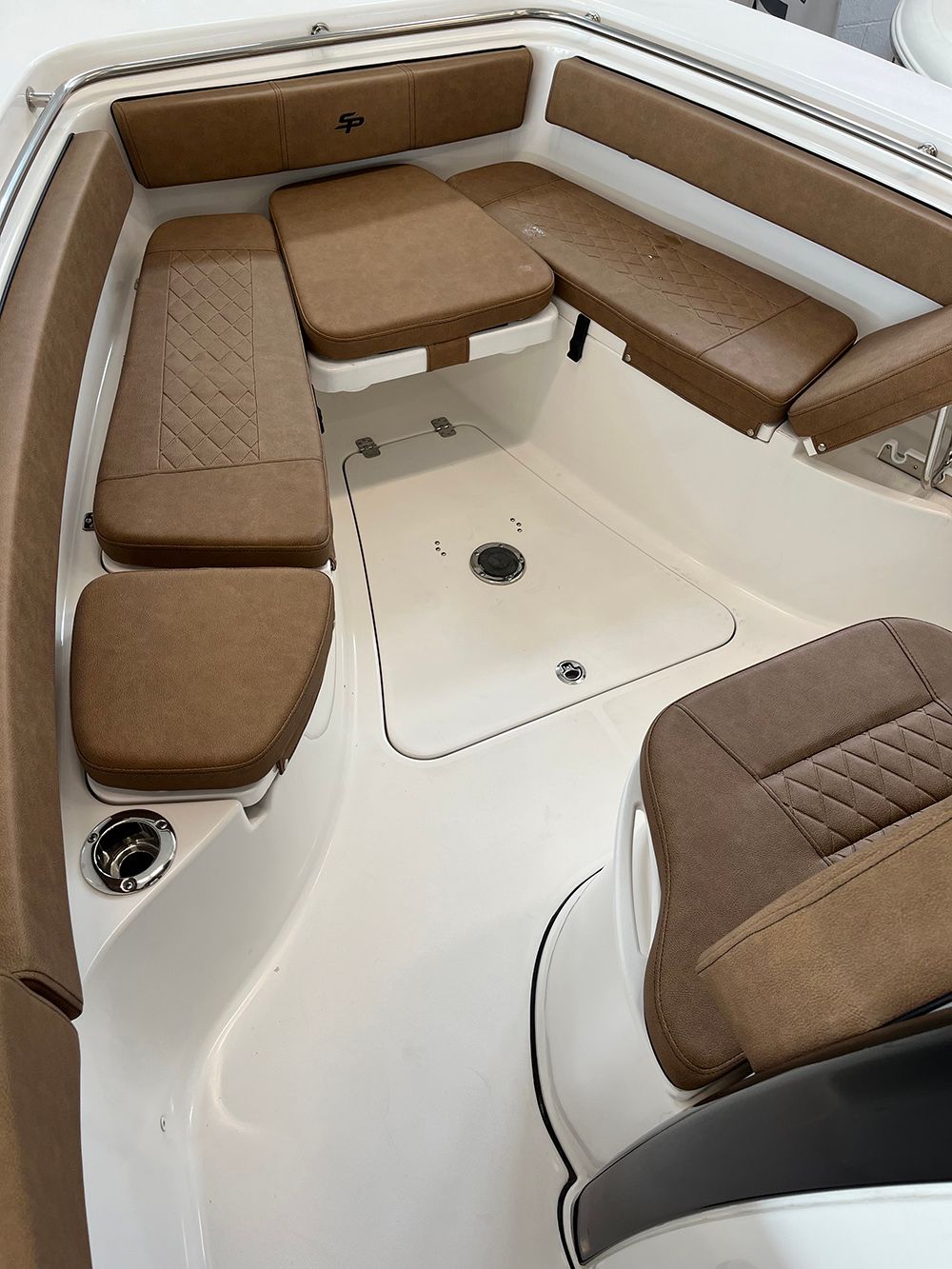 The inside of a boat with brown seats and a table.