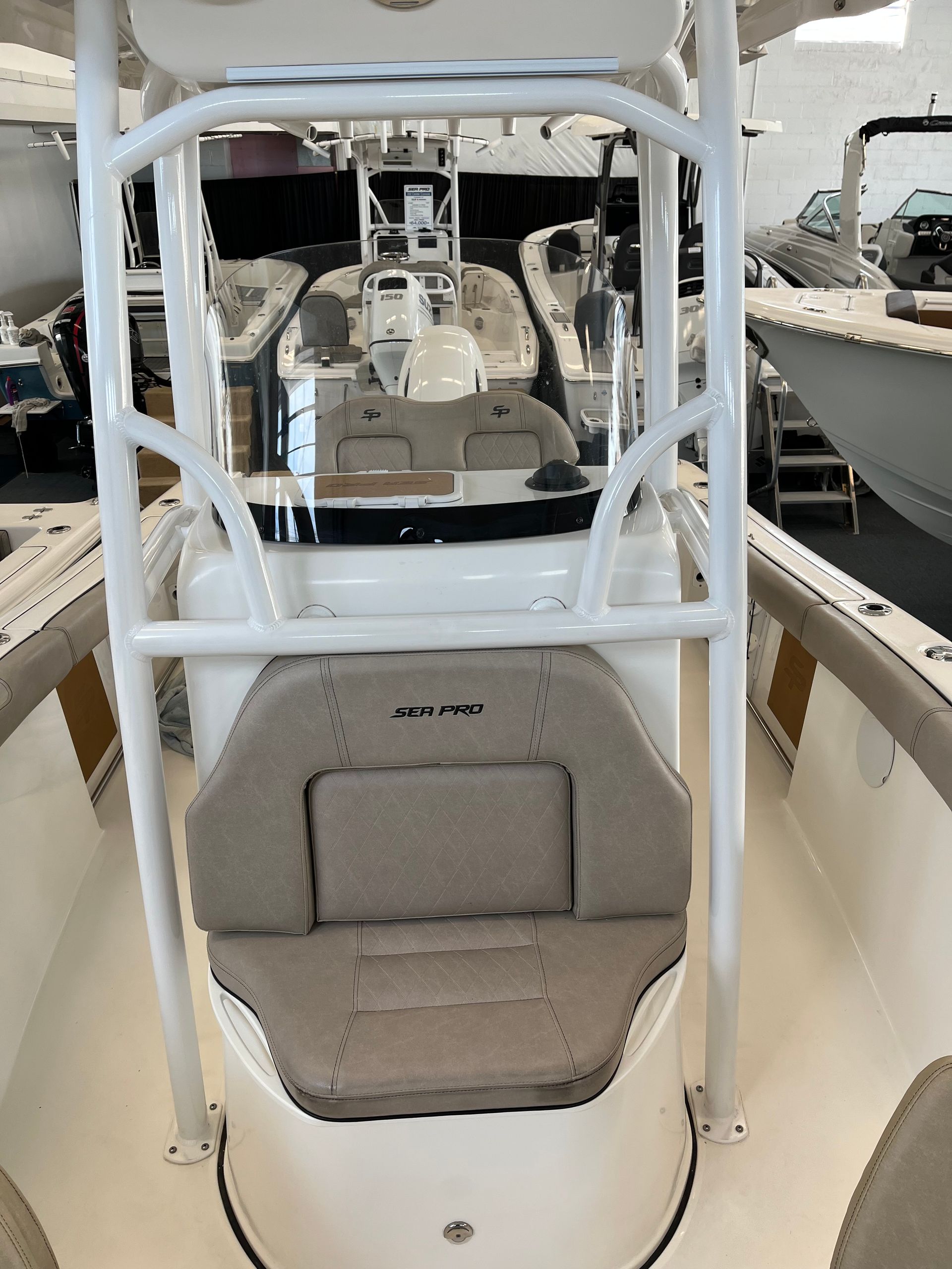 Interior view of a white boat with a large beige cushioned seat.
