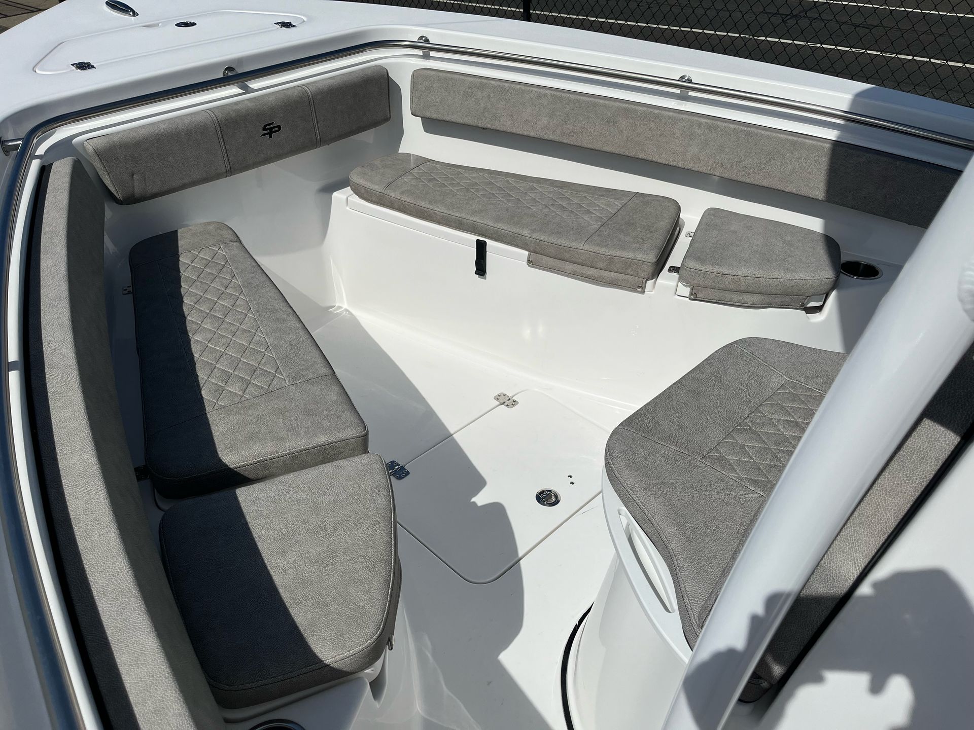 A white boat with gray seats and cushions