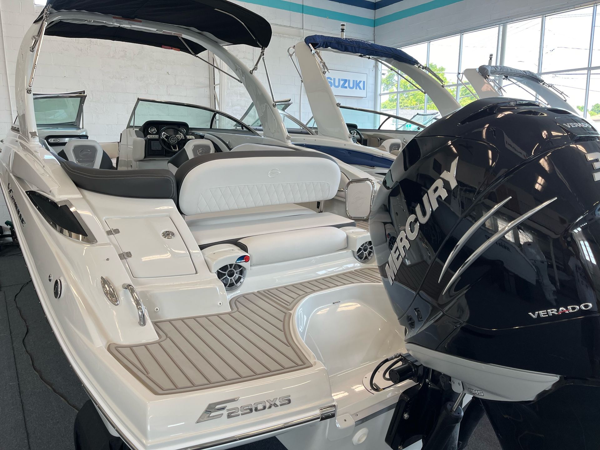 A boat with a mercury engine is sitting in a showroom.