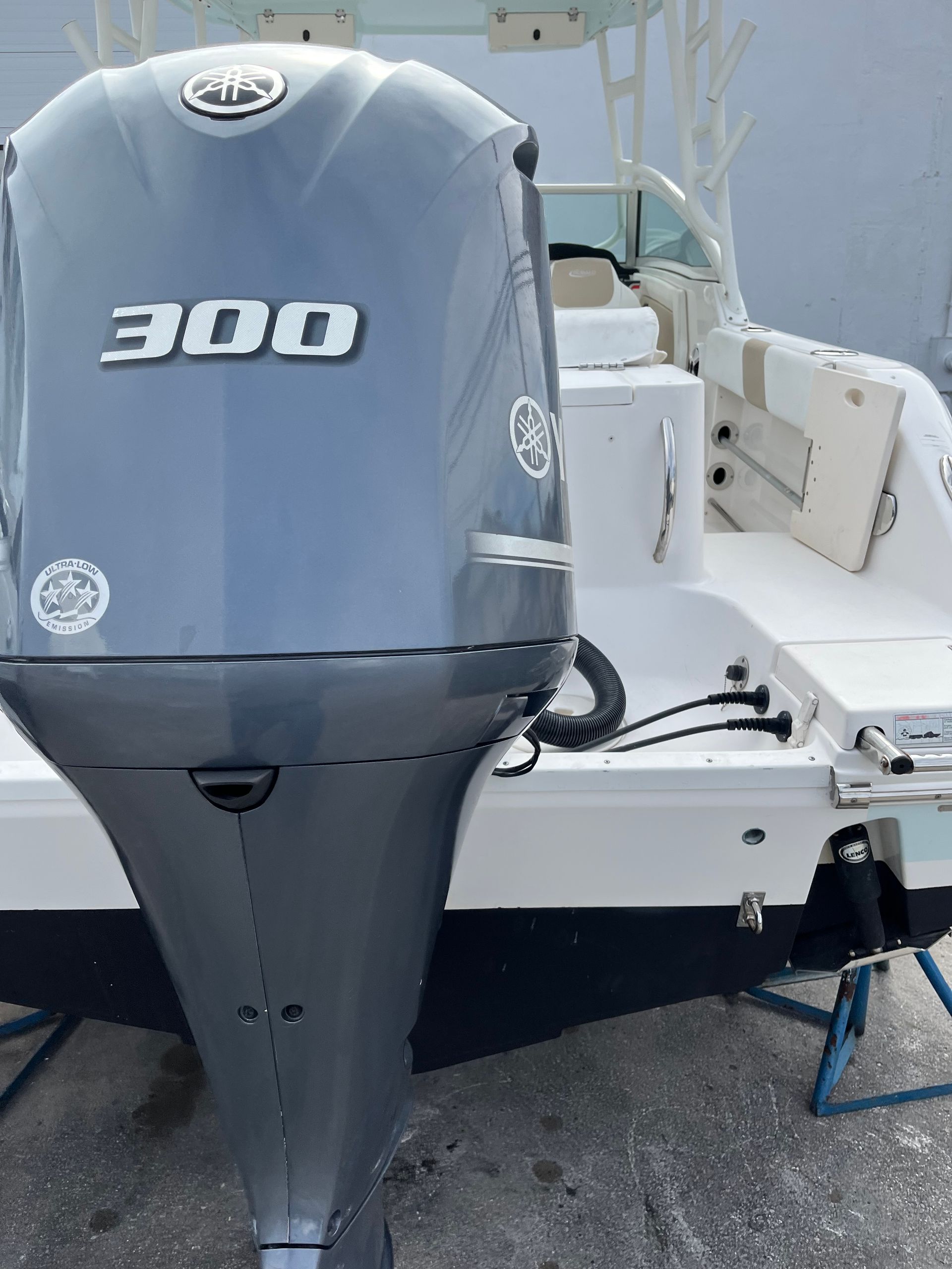 Gray 300 hp outboard motor on a white boat docked by the water