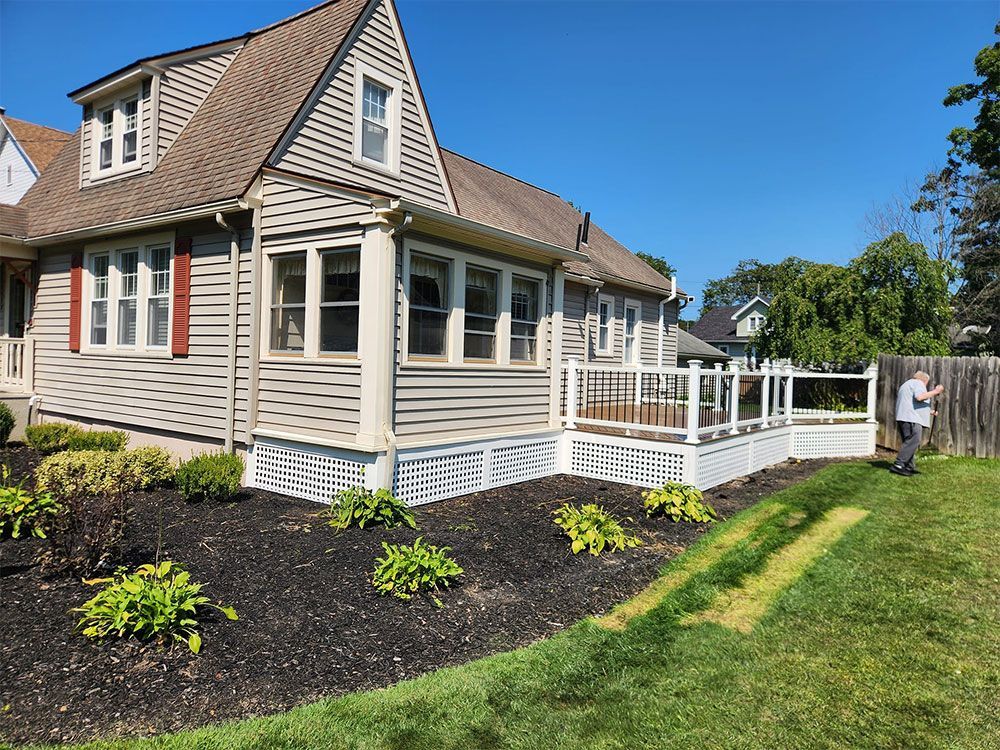 A man is standing in front of a house with a deck