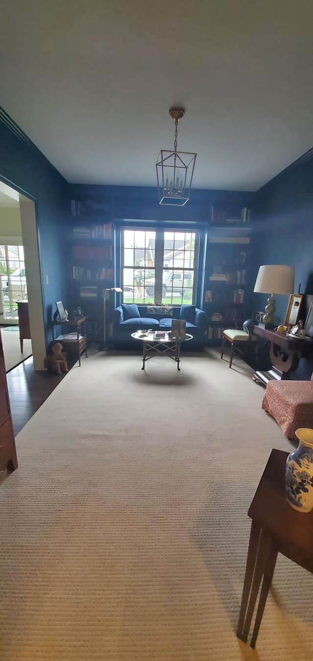 A living room with blue walls and a white rug.