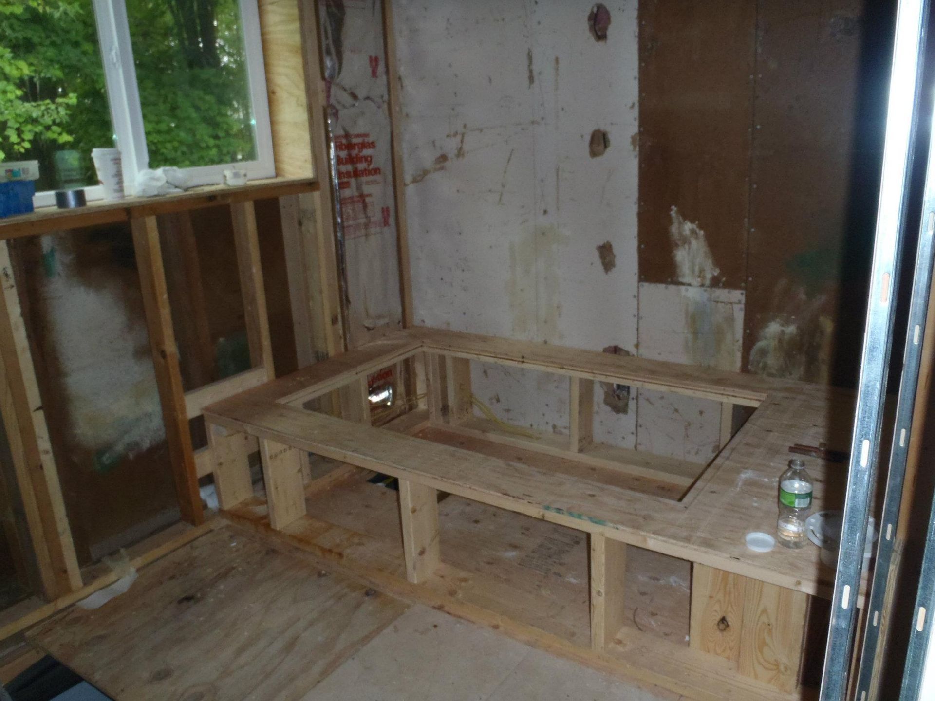 A wooden bathtub is being built in a bathroom.