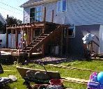 A house is being built with a deck and stairs in the backyard.