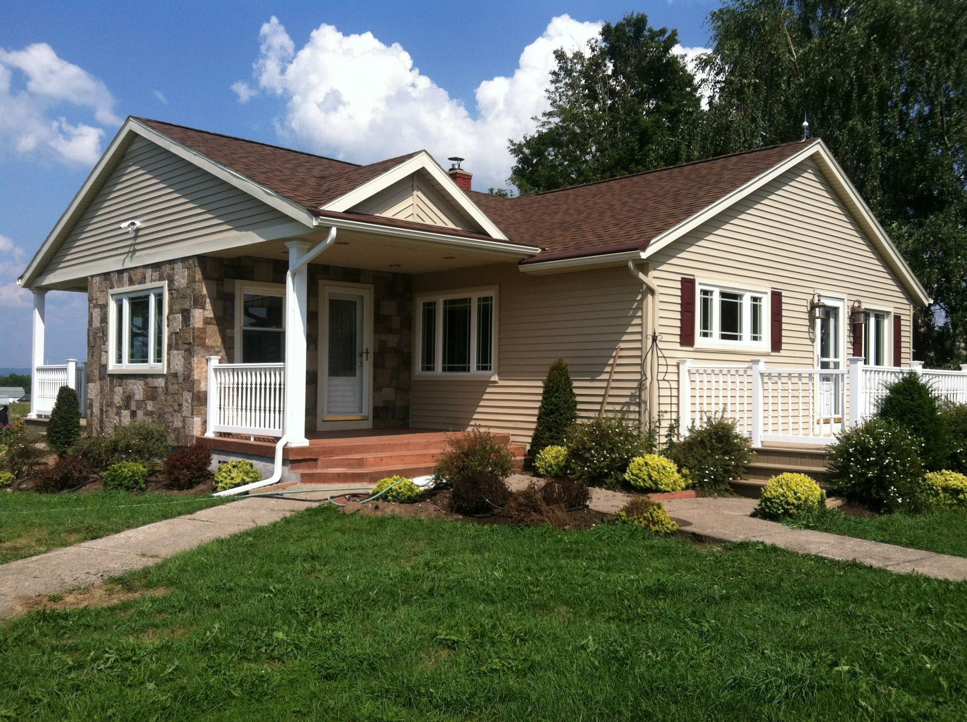 A house with a brown roof and a white porch