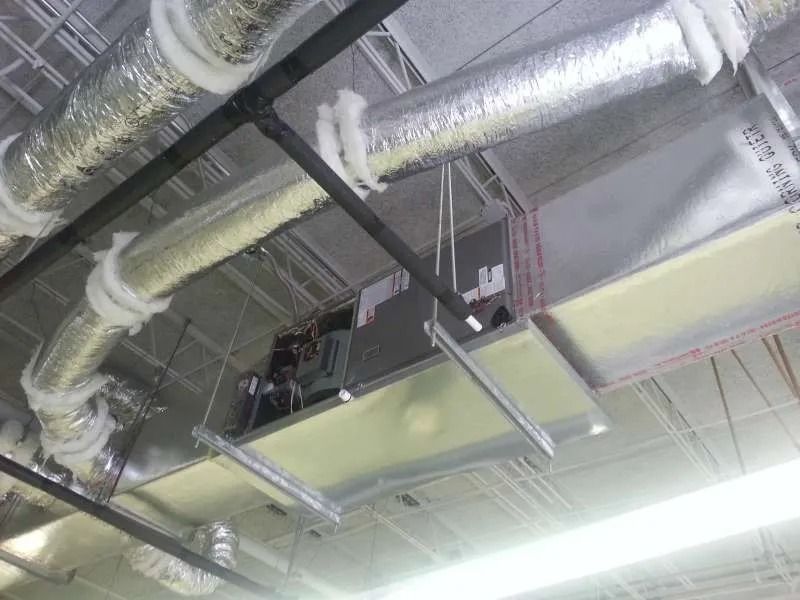 HVAC system installation in a commercial building; ductwork, panels, and equipment suspended from the ceiling.