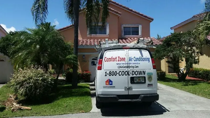 White service van in front of a house, advertising 