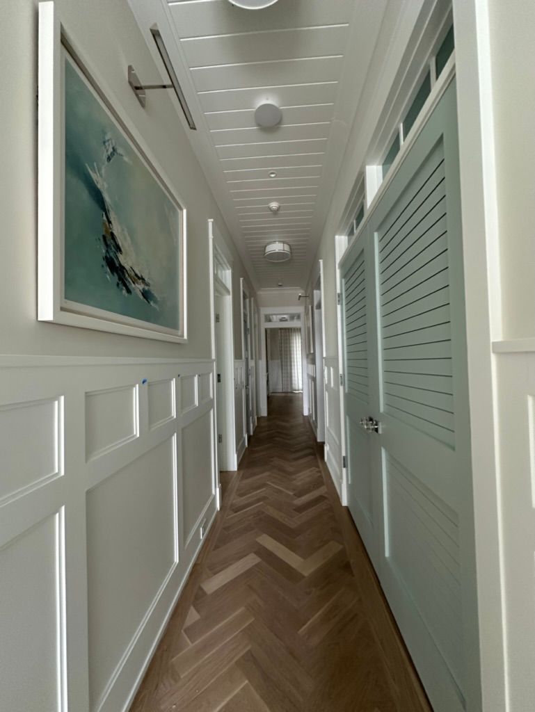 A long hallway with a picture of a sailboat on the wall