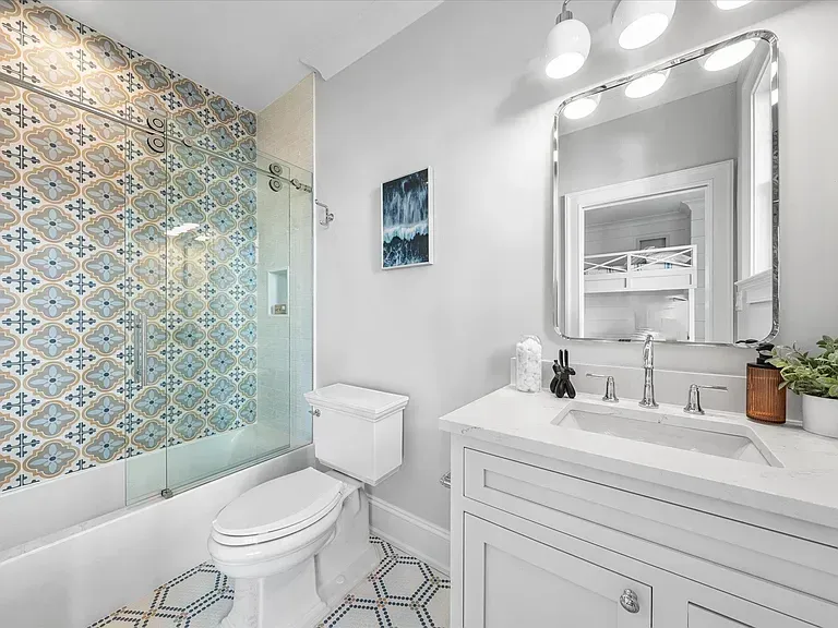 A bathroom with a toilet, sink, and shower.