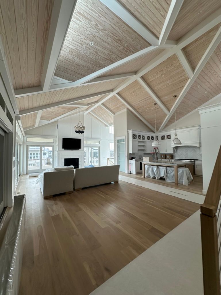 A living room with a vaulted ceiling and hardwood floors
