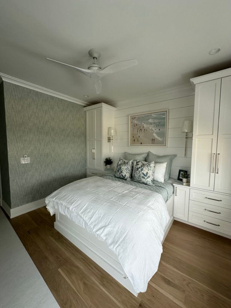 A bedroom with a large bed and a ceiling fan.