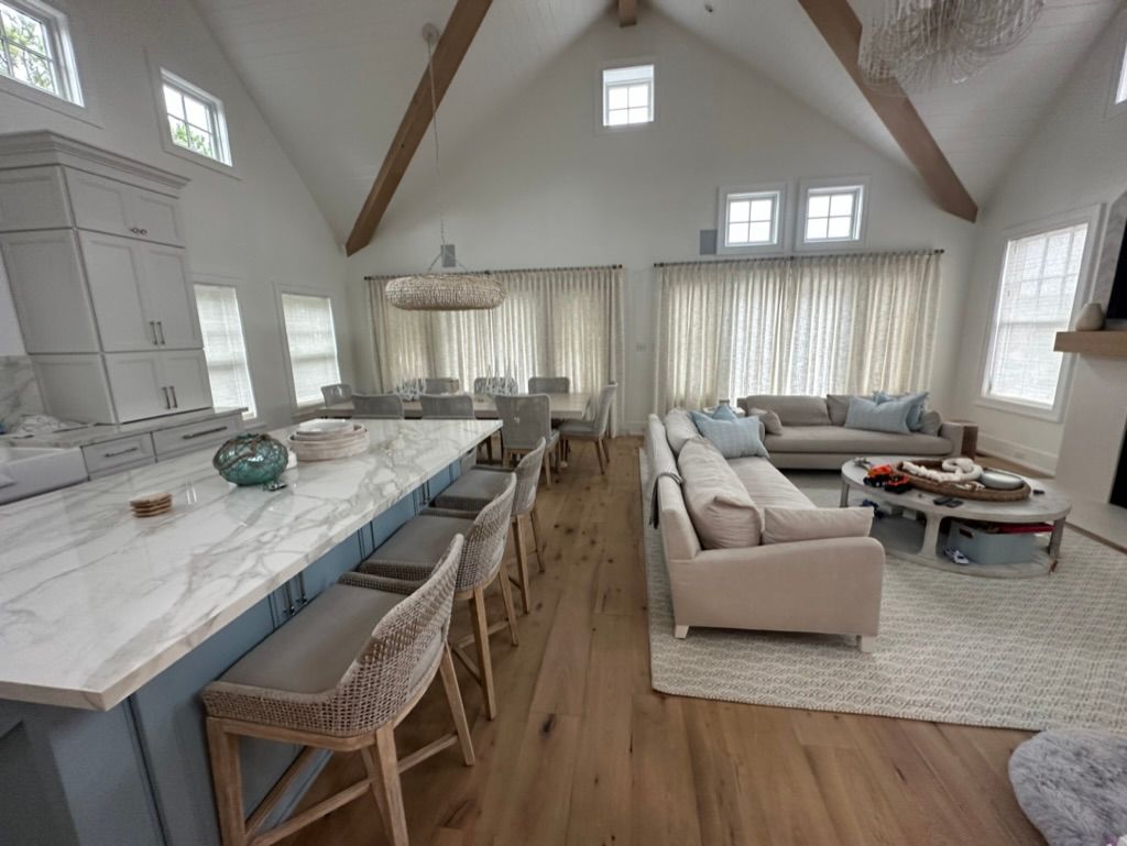 A living room with a couch, table, chairs, and a vaulted ceiling.