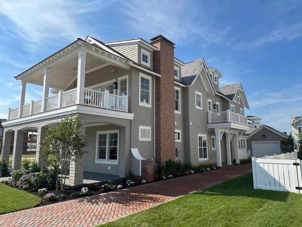 A large house with a brick driveway in front of it.