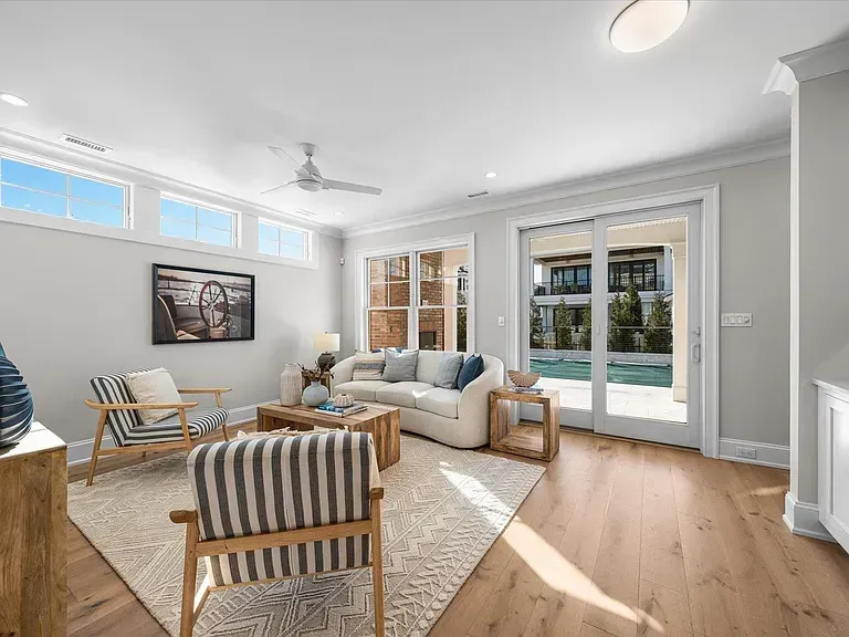 A living room with a couch, chairs, and a ceiling fan.