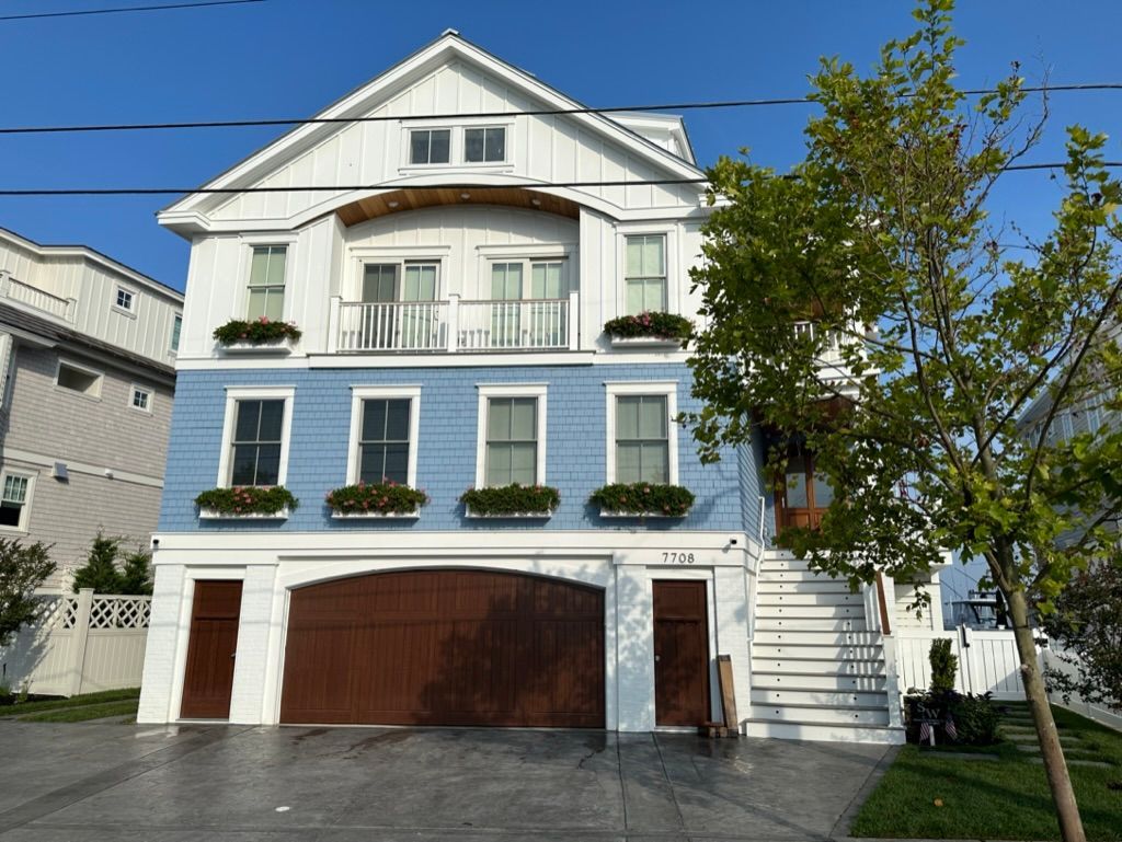 A large blue and white house with a brown garage door