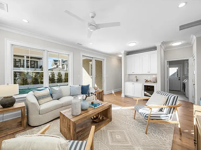 A living room with a couch, chairs, coffee table, and ceiling fan.