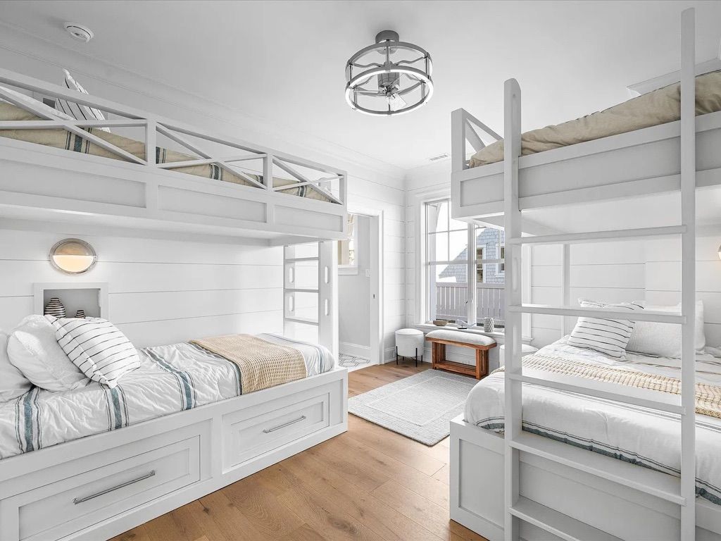 A bedroom with three bunk beds and a chandelier.