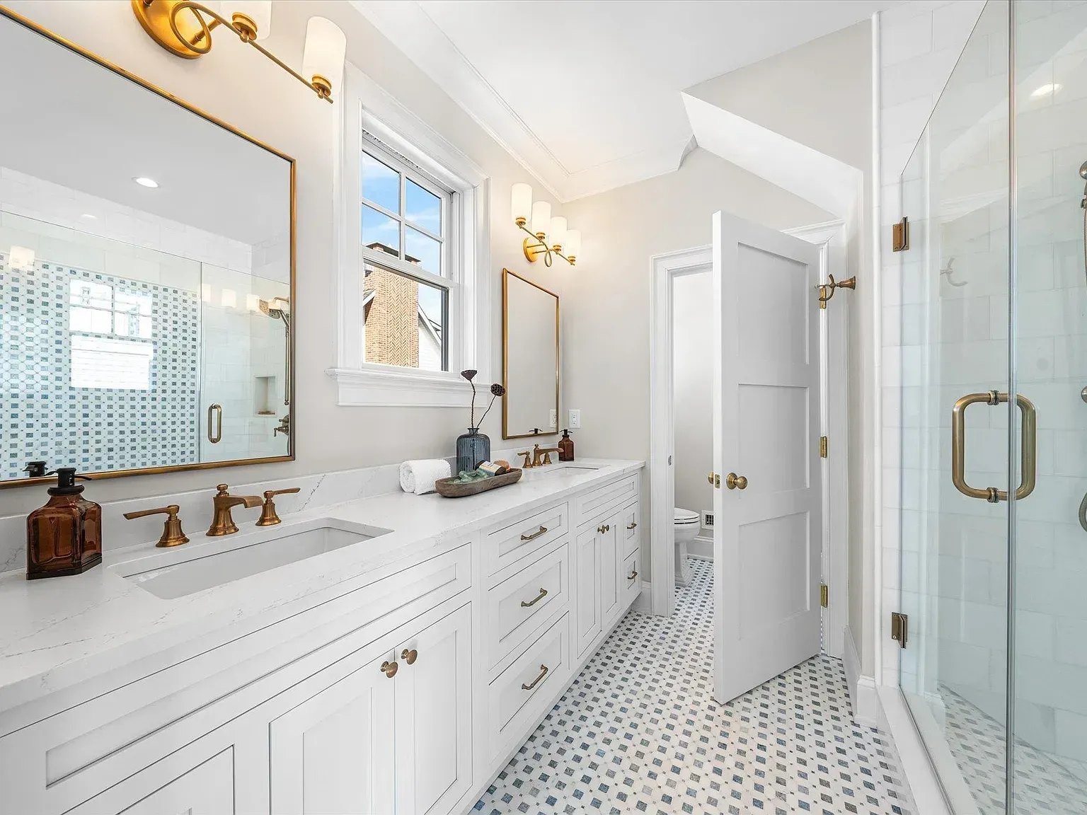 A bathroom with two sinks and a walk in shower.