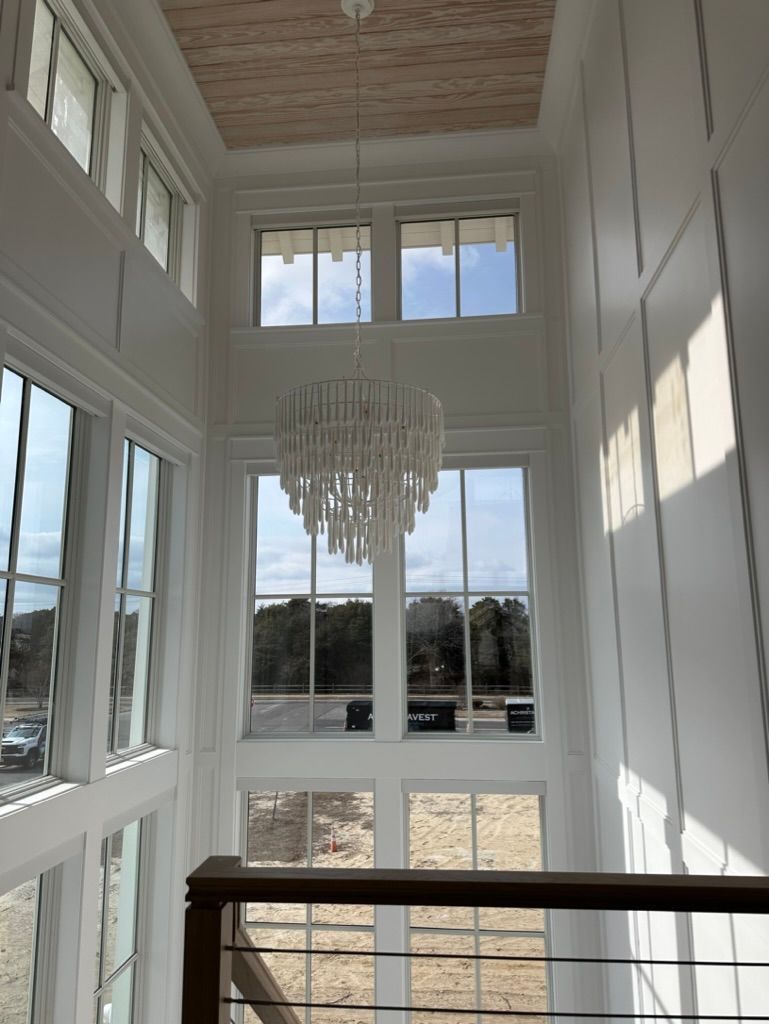 A large room with lots of windows and a chandelier hanging from the ceiling.