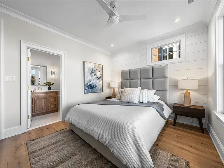 A bedroom with a large bed and a ceiling fan.