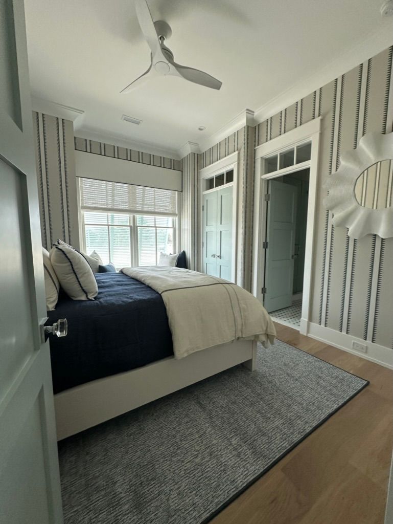 A bedroom with a bed and a ceiling fan.