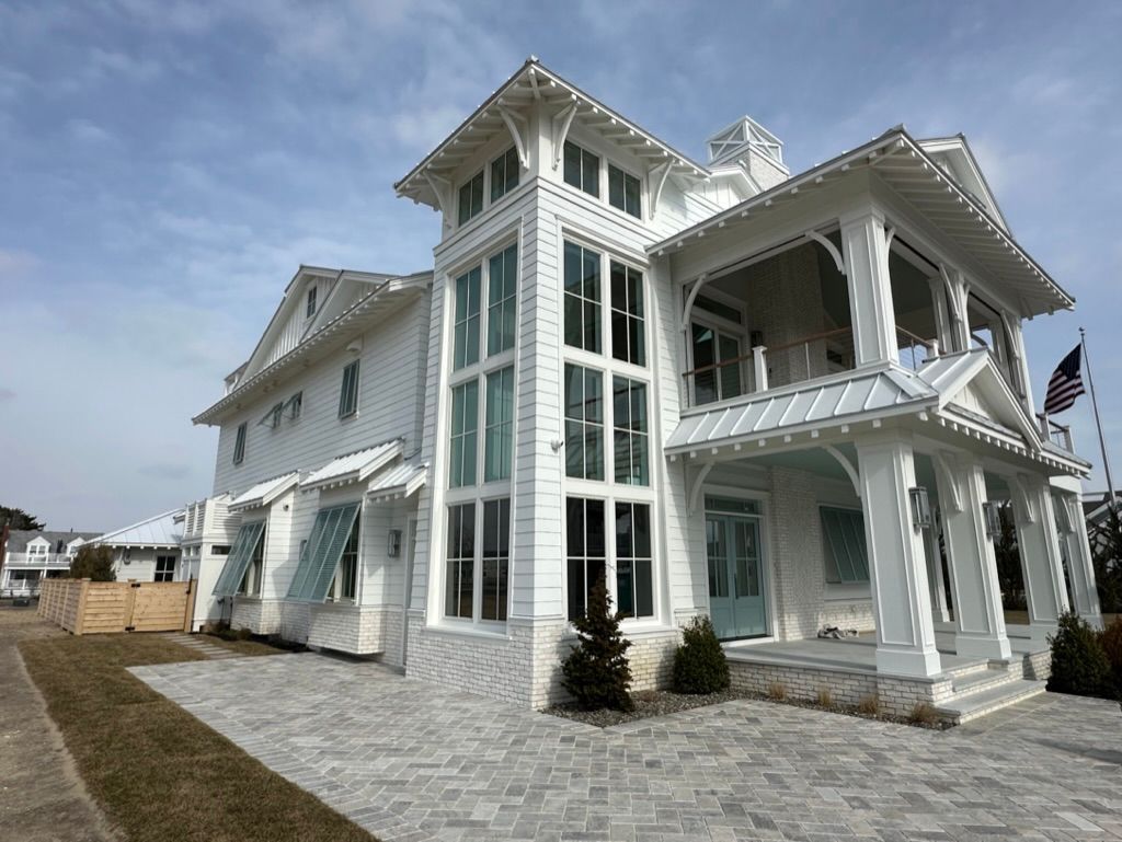 A large white house with a large porch and lots of windows