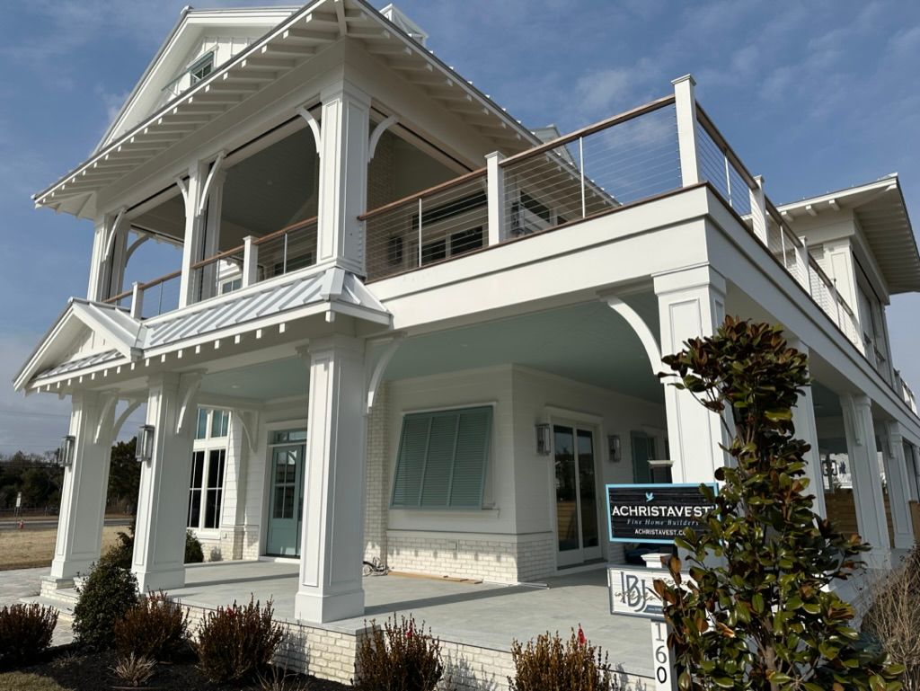 A large white house with a for sale sign in front of it
