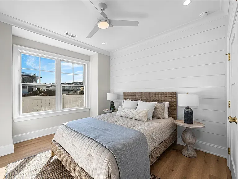 A bedroom with a bed and a ceiling fan.