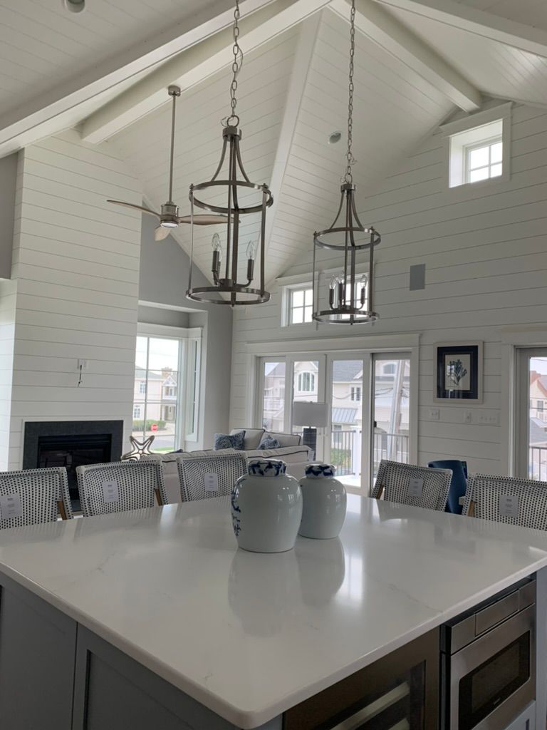 A kitchen with a large island and white counter tops