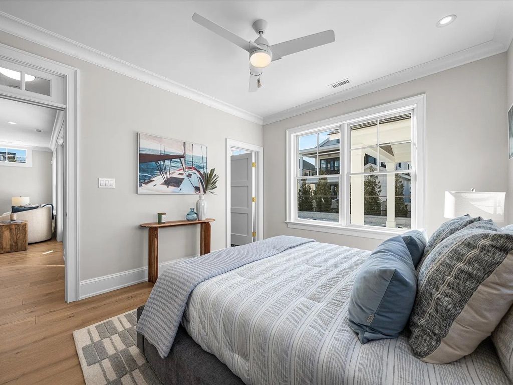 A bedroom with a large bed and a ceiling fan.