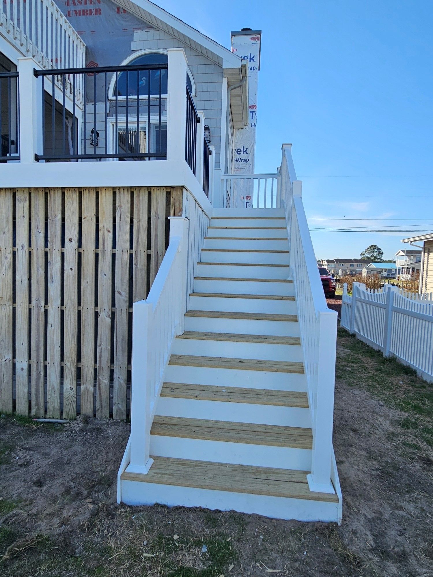 There are stairs leading up to the deck of a house.