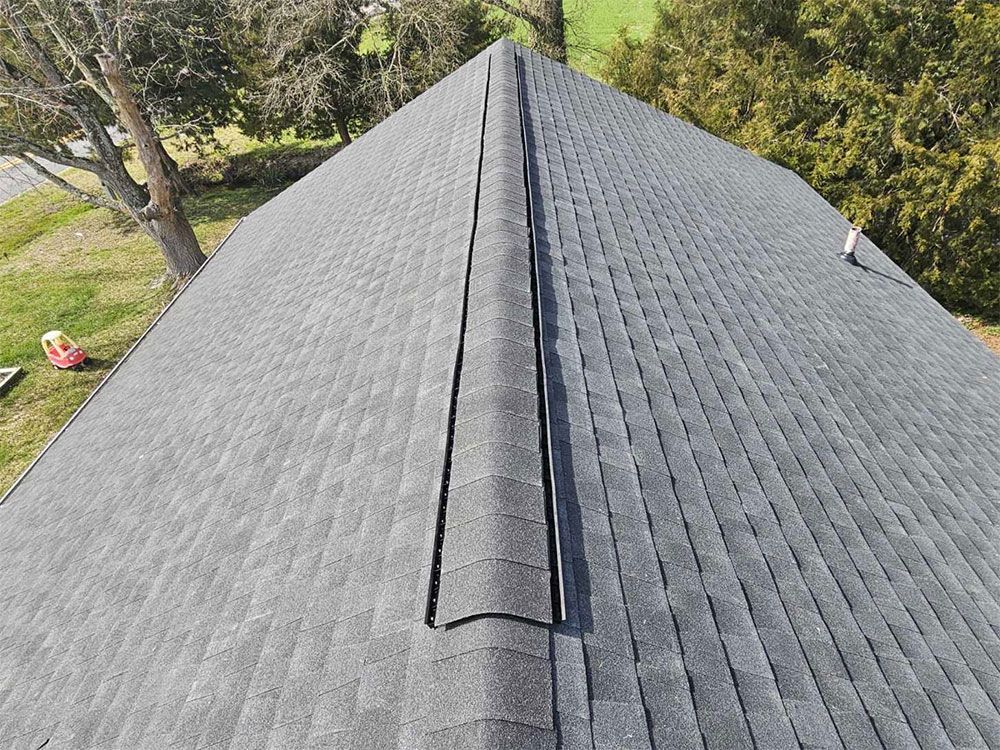 An aerial view of a roof with a tree in the background