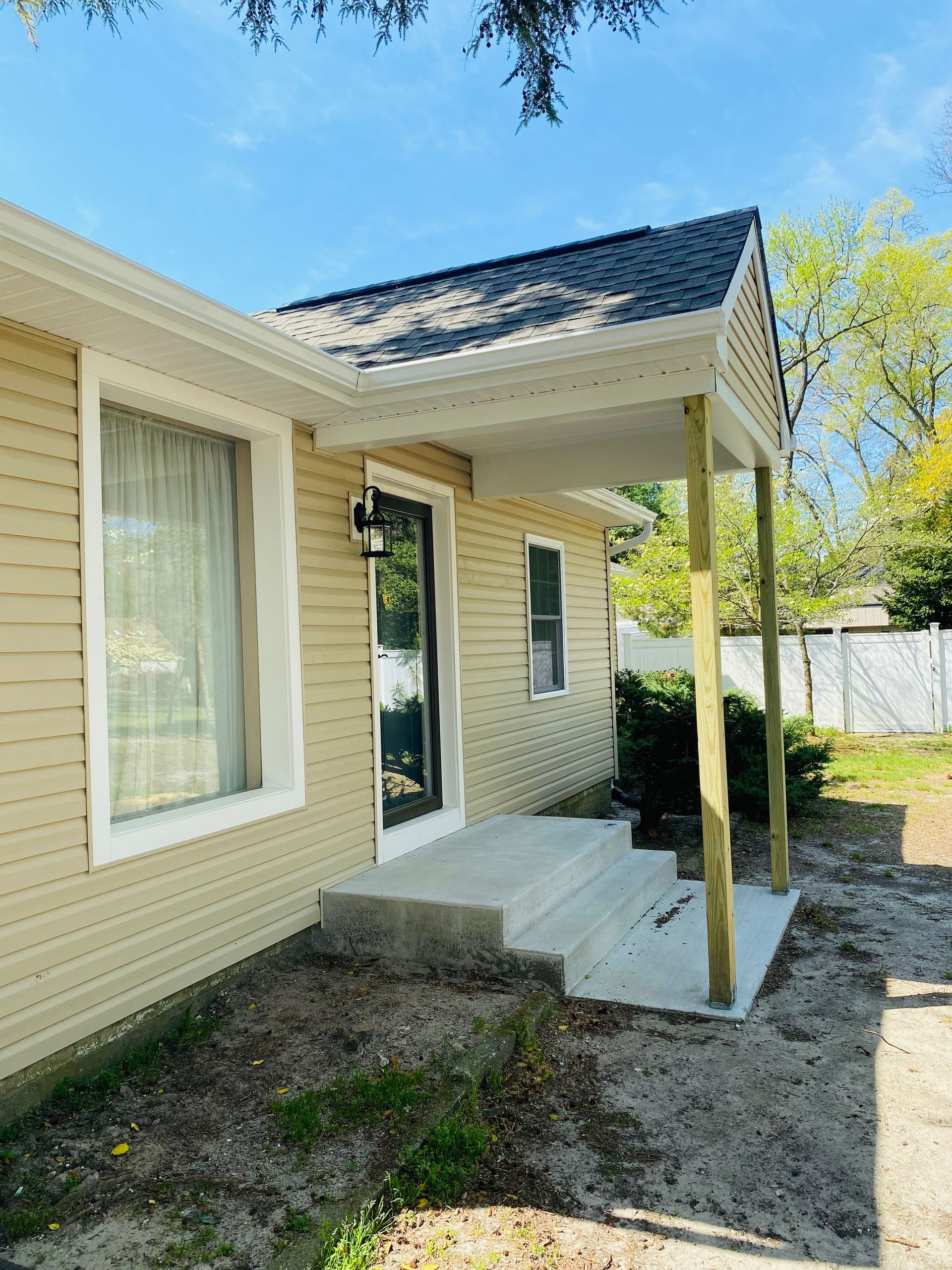 A house with a porch and stairs on the side of it.