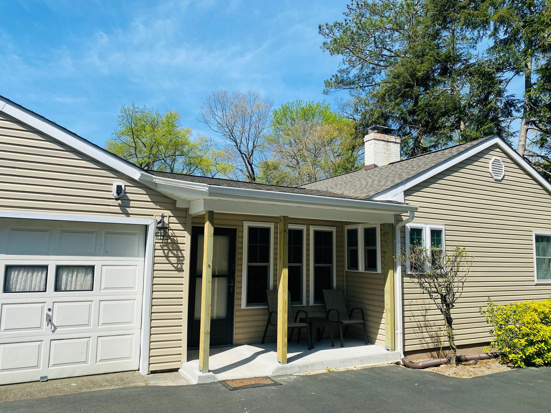 A house with a garage and a porch on a sunny day