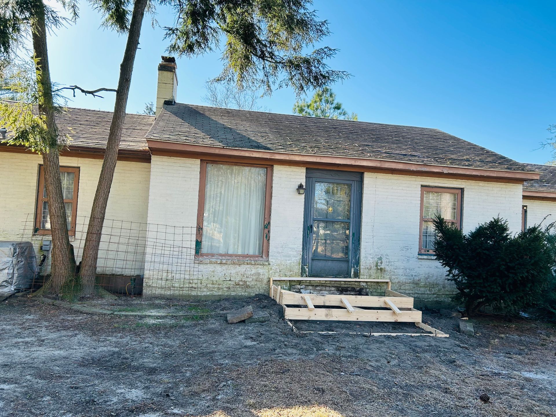 A white house with a wooden pallet in front of it