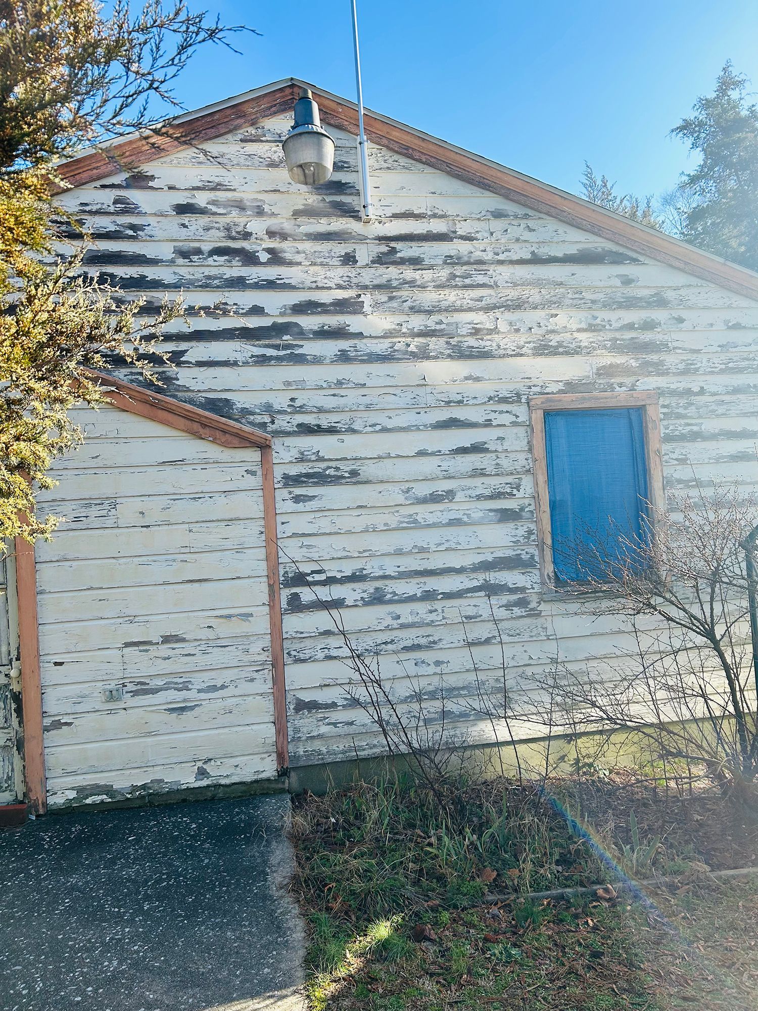The back of a white house with a blue window.