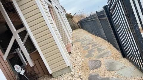 a stone walkway leading to a building next to a fence .