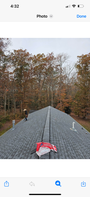 A phone screen shows a picture of a roof with trees in the background.