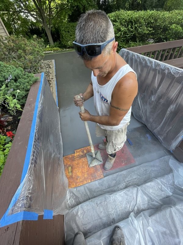 Worker waterproofing the inside of a rooftop structure with gray liner and blue tape.