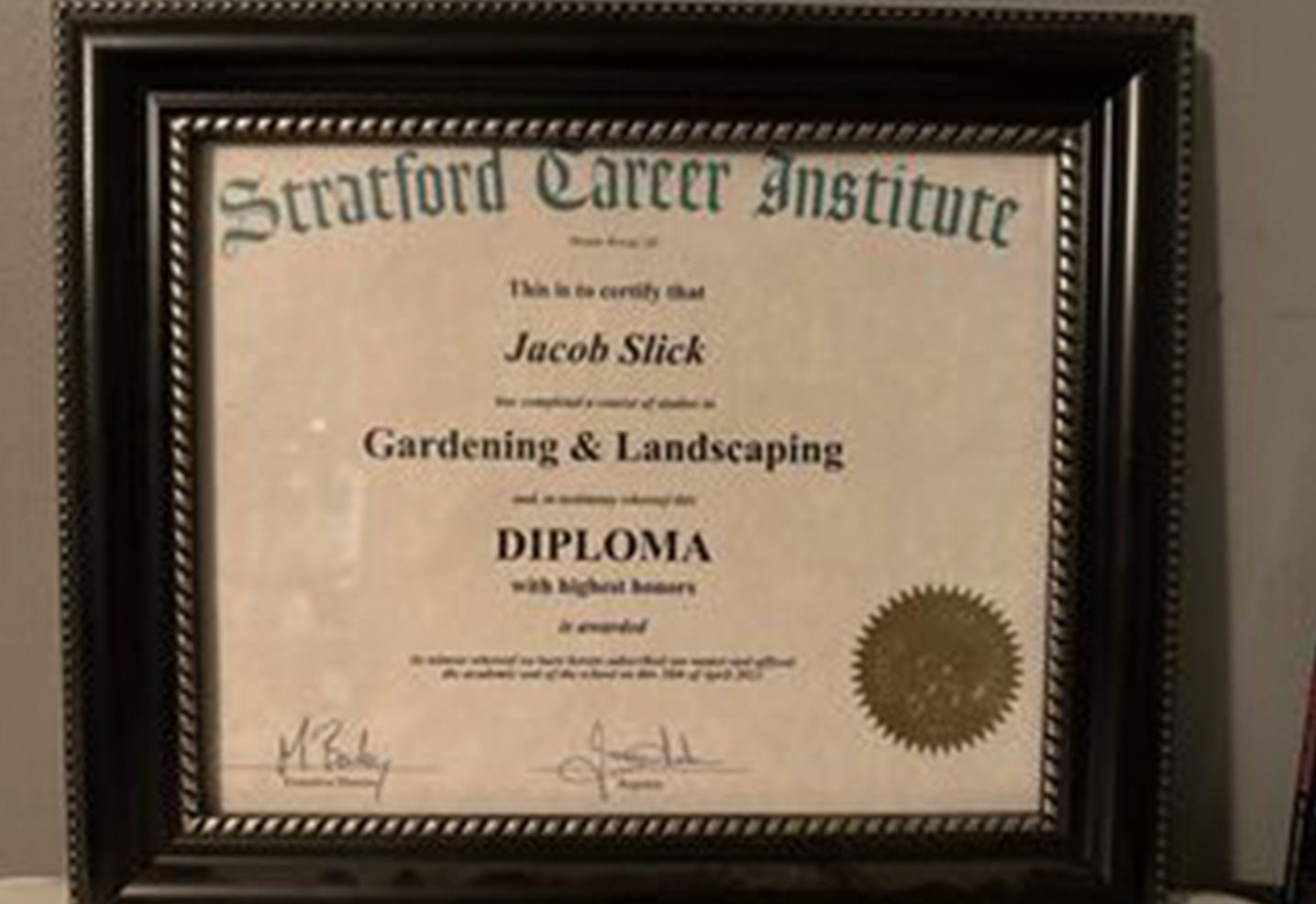 Framed Stratford Career Institute diploma in a dark wood frame on a wall