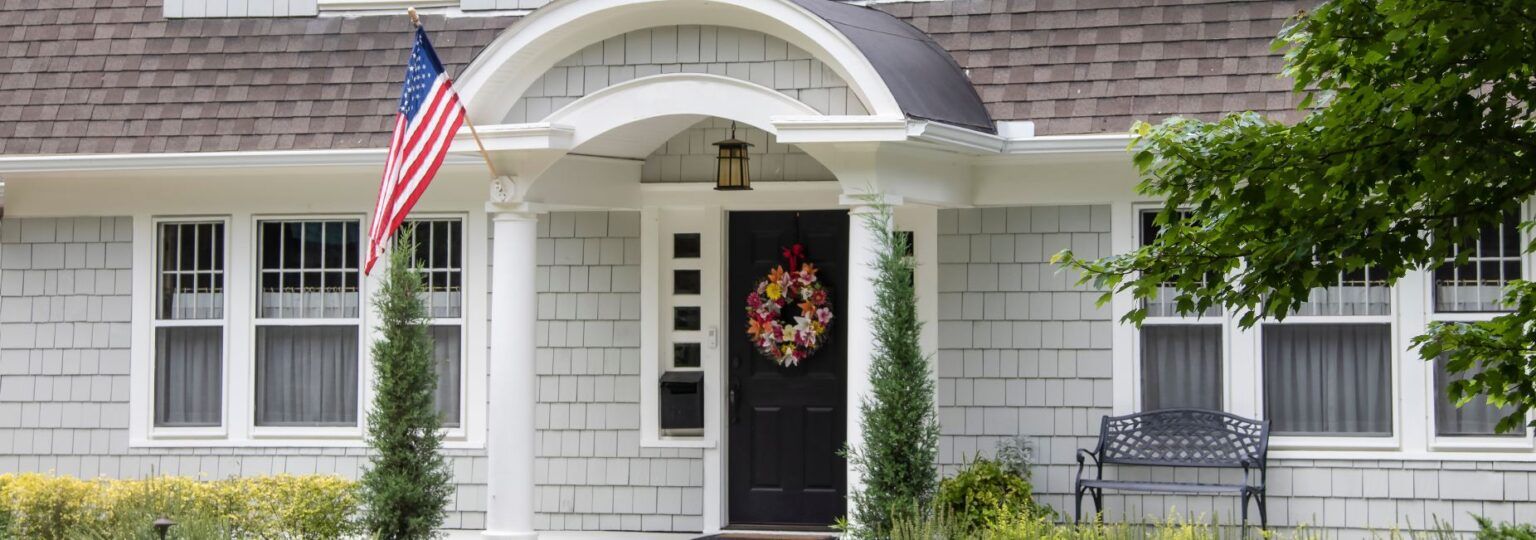 A white house with an american flag on the porch