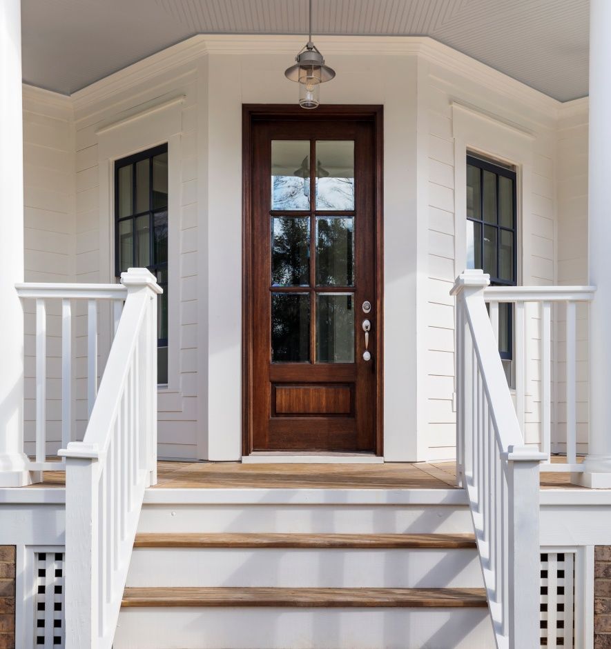 A white house with a wooden door and stairs
