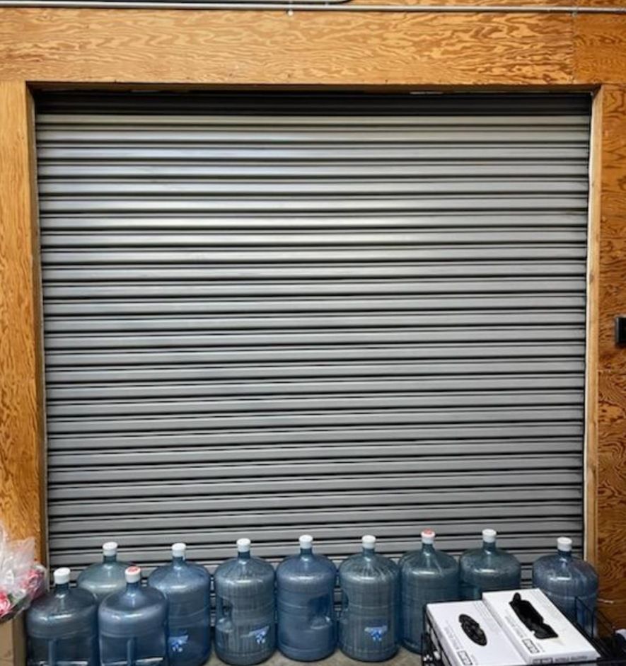 A row of water bottles are lined up in front of a garage door.