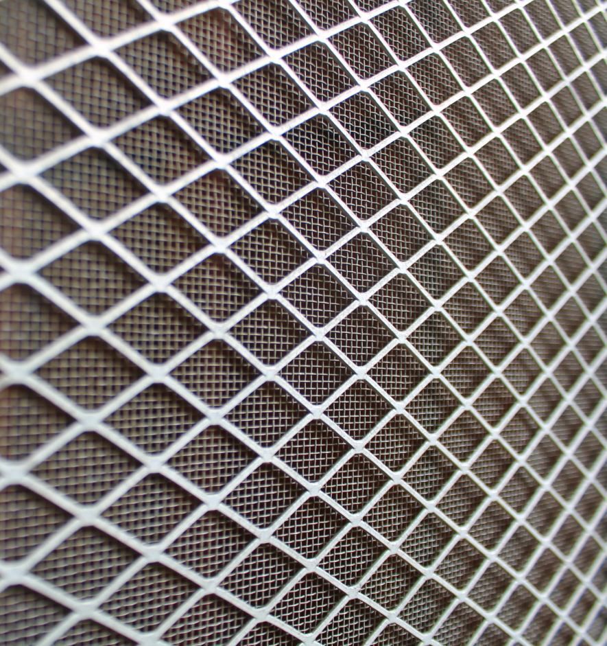 A close up of a metal mesh screen on a wall.