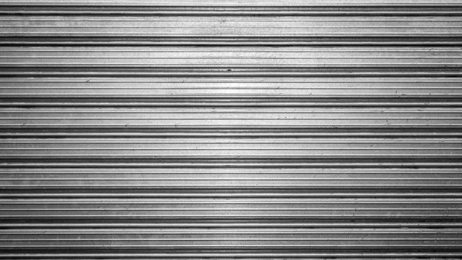 It is a black and white photo of a metal shutter.