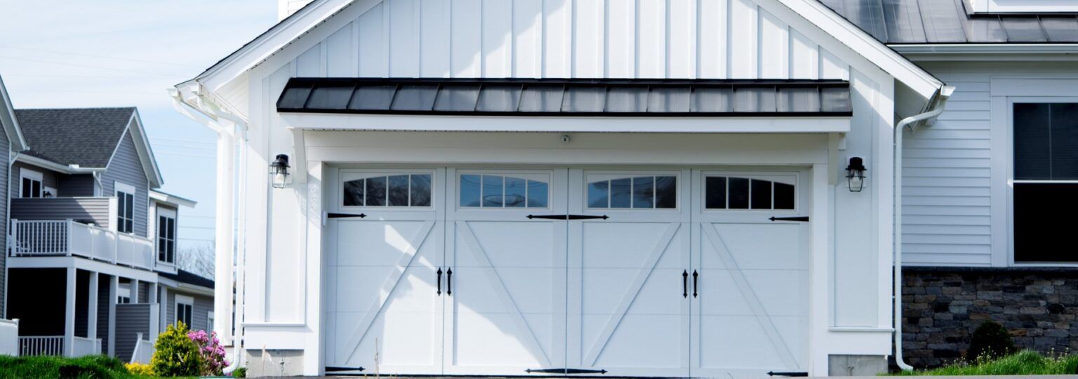 A white house with a large white garage door.