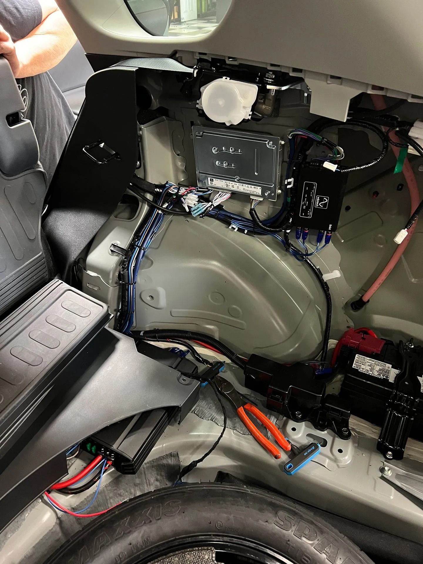 A car with the trunk open and a lot of wires coming out of it.