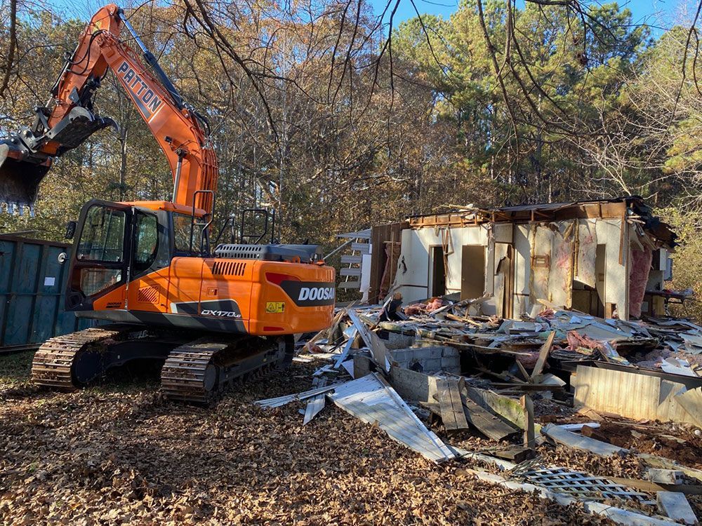 Backhoe loader clearing a property